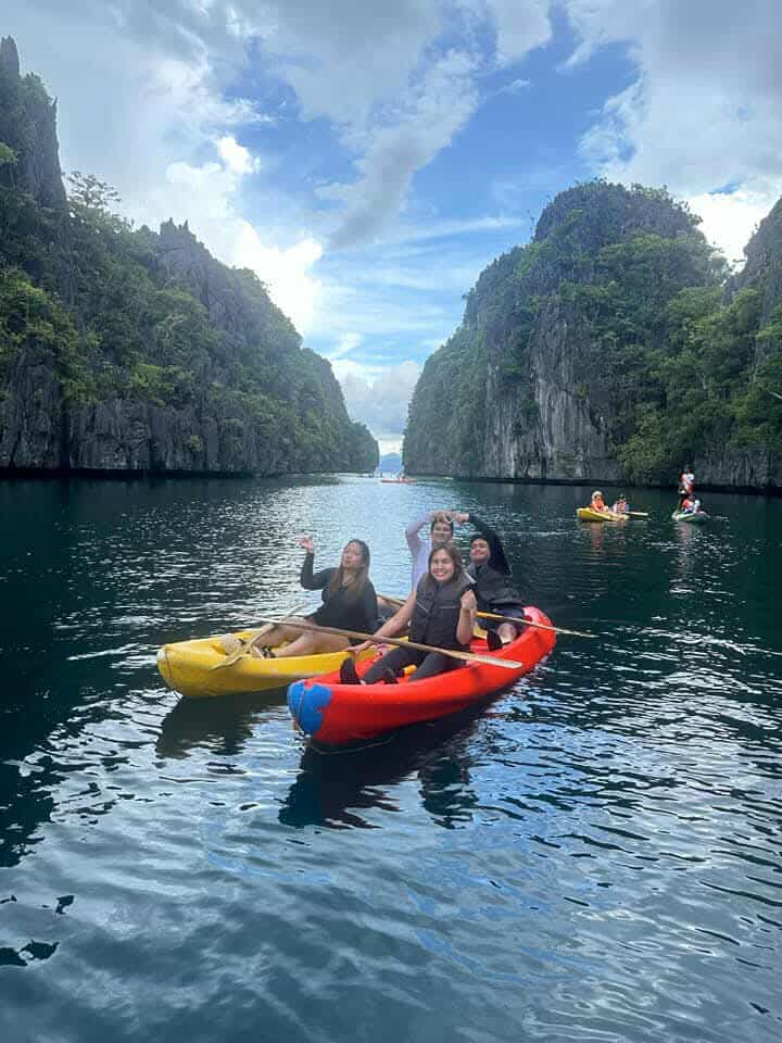 Kayaks on a lagoon surrounded by limestone cliffs in El Nido