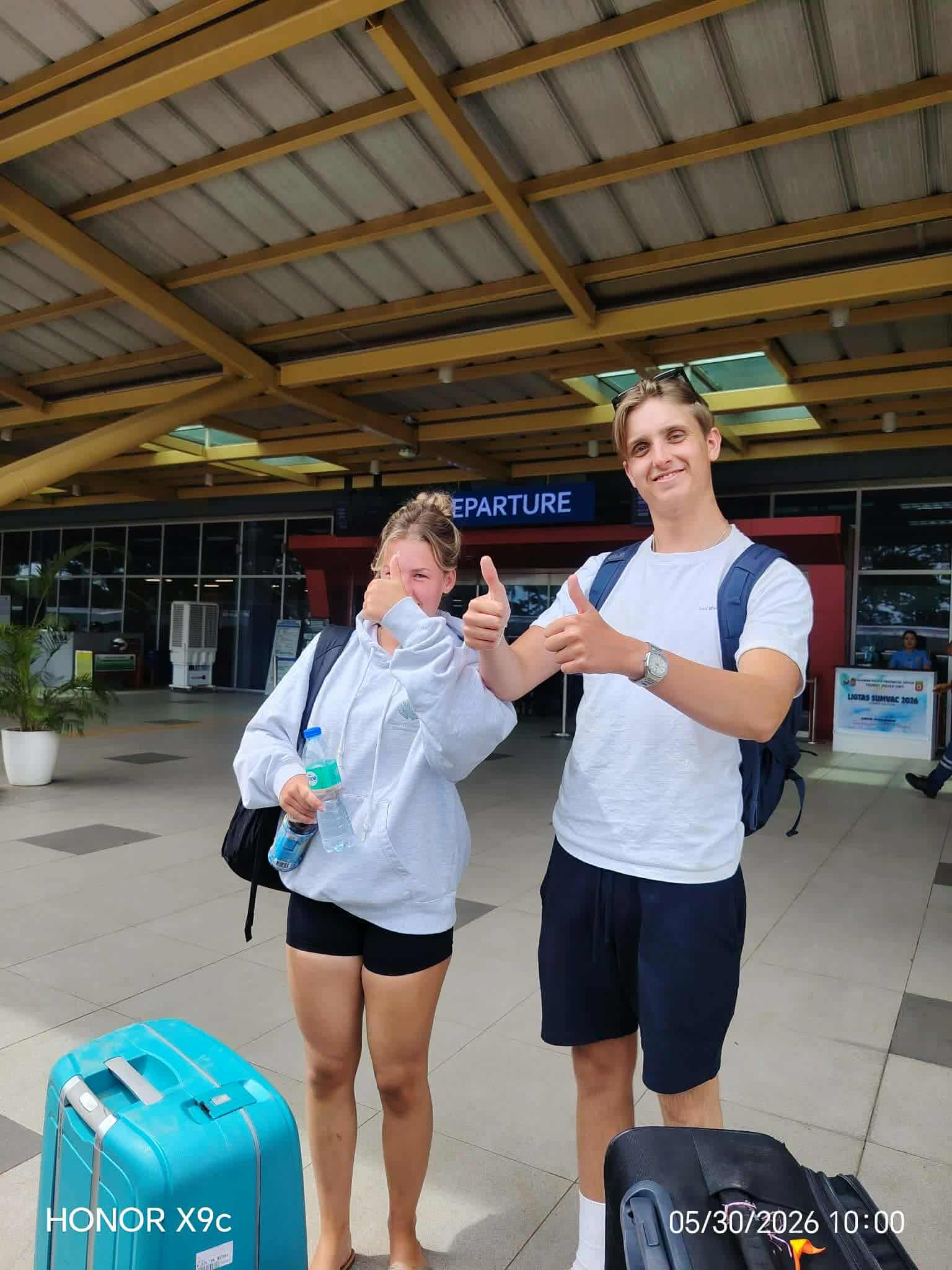 Couple with their luggage at Puerto Princesa Airport before their private van transfer to El Nido